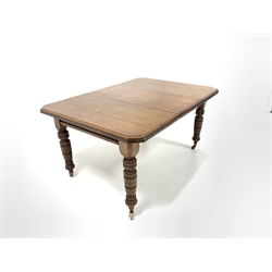 Edwardian mahogany wind out extending dining table, the top with canted corners over turned supports and brass and ceramic castors, one additional leaf 