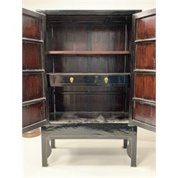 Chinese black lacquer marriage cabinet, the sides with geometric gilt painted decoration, two doors enclosing an interior fitted with two shelves and one long drawer, raised on square section supports W115cm, H184cm, D63cm