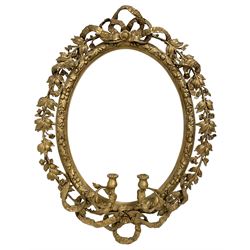 19th century gilt wood and gesso girandole wall mirror, oval frame with ribbon tied pediment intertwined with trailing foliage branch, decorated with small flower heads, the inner frame decorated with foliate and thistle mouldings, two branch candelabra surrounded by lower ribbon tie