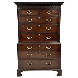 George III mahogany chest on chest, the projecting dentil cornice over blind fretwork frieze and canted corners, two short and six long drawers, cast gilt metal cartouche escutcheons and ornate handles, on bracket feet