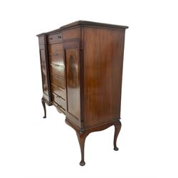 Edwardian music or filing cabinet, moulded reverse break-front top over bank of six slides and drawer, the top drawer in turn opens the two flanking cupboards on hinged and lockable Wellington type mechanism (meaning that the cabinet is completely locked), the panelled doors with figured oval inlay and band, on cabriole supports (no key)