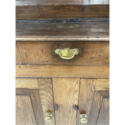 18th century oak dresser, the projecting cornice over two height plate rack and three drawers and two cupboards, raised on stile supports