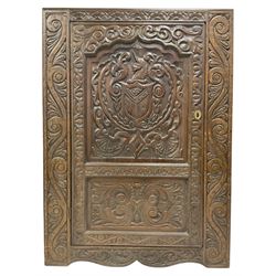 Late 19th century gothic revival oak freestanding cupboard, the front carved with lunette frieze, the panelled door heavily carved with a central heraldic crest with unicorn over a shield, flanked by scrolling foliate decoration, fitted with two shelves, raised on shaped plinth base