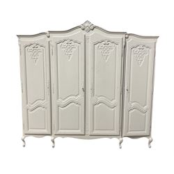 20th century French style white painted triple Armoire wardrobe, the shaped projecting shell pediment over four doors, raised on scrolled cabriole supports W220cm, H205cm, D60cm 