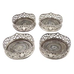 Set of four Victorian silver coasters with pierced sides engraved with a crest and with turned wooden bases D13cm London circa 1855 Maker Charles Boyton  Provenance: 2nd Baron Feversham