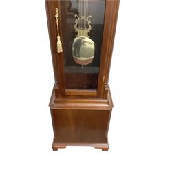 20th-century - 8-day mahogany longcase clock, with a swans neck pediment and fully glazed trunk door, visible brass cased weights and pendulum, three train weight driven chiming movement chiming the quarters and hours on 12 going rods, with a brass dial, silvered chapter ring, working moon dial and strike/silent facility.. With weights and pendulum.