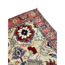 Persian Heriz rug, ivory ground field with stylised plant and geometric decoration, the border decorated with stylised flower head motifs surrounded by guards with repeating Boteh motifs