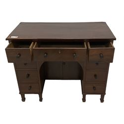 Regency mahogany kneehole desk, fitted with central drawer over arched recess and double cupboard, flanked by eight ebony strung drawers with turned ebony handles, lower reeded edge over square tapering supports with spade feet