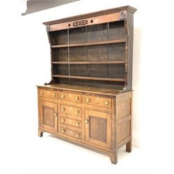 19th century oak and mahogany banded dresser, projecting cornice over pierced frieze on three height plate rack, four drawers, two faux drawers and two fielded cupboards to base, raised on shaped bracket supports