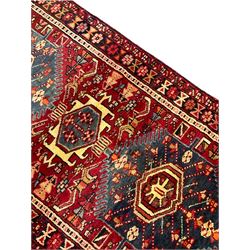 Persian red ground runner, decorated with six trailing geometric medallions, the field decorated with small stylised motifs, thee band border with geometric design