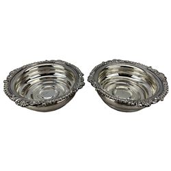 Pair of silver bottle coasters with gadrooned and shell moulded borders on a wooden base D16cm