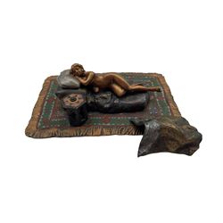 A cold painted bronze of a reclining nude lady on a rug in the manner of Bergman, stamped beneath, 15.5cm x 10cm