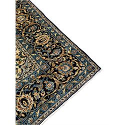 Persian Kashan indigo ground carpet, the central floral medallion surrounded by all-over foliate motifs and palmettes, the dark indigo field with pale contrasting spandrels, the multi-band border with repeating interlaced palmettes and branches