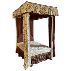 Cream painted 4' small double four poster bed, turned and fluted upright supports on stepped and moulded plinths, shaped headboard upholstered in red fabric, draped in floral pattern fabric 
Provenance: From the Estate of the late Dowager Lady St Oswald