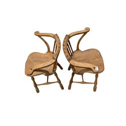 Pair of smokers bow armchairs, the spindle back over saddle seat, raised on turned supports, together with mahogany tripod table