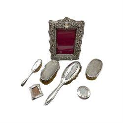 Late Victorian silver upright photograph frame with embossed decoration 22cm x 16cm Birmingham 1900, four various silver backed brushes and two small silver photograph frames
