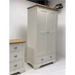 Contemporary oak and cream finish double wardrobe, with interior fitted with shelf and for hanging over one drawer, raised on shaped bracket supports, (W99cm, H195cm, D58cm) together with a matching chest fitted with two short and two long drawers, (W100cm, D90cm, D49cm)
