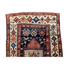 Antique Afghan Kazak red ground rug, the indigo field with two geometric medallions surrounded by stylised animal motifs, the guarded ivory border decorated with repeating geometric patterns