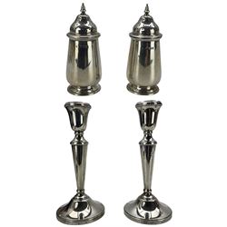 Pair of silver pepperettes with pierced covers H9cm London 1927 Maker Blackmore & Fletcher and a pair of silver candlesticks H19cm Birmingham 1978 Maker William Adams (4)