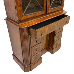 19th century figured walnut bookcase on cabinet, two astragal glazed doors with surrounding feather stringing enclosing three adjustable shelves over three correspondence drawers with turned bone handles, the collector's kneehole base fitted with eight assorted drawers, two with removable facias revealing small collectors drawers with coin trays, central recessed cupboard enclosing shelf, all flanked by quarter-canted fluted pilasters, on shaped skirted base