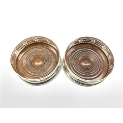 Matched pair of silver bottle coasters with pierced decoration and turned mahogany bases D13cm Birmingham 1867 and 1899 Maker George Unite