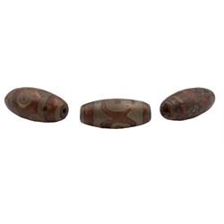 Three Tibetan Dzi stone beads each with decorative symbols approx 3cm long 