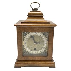A small mid-20th century mantle clock in the style of an 18th century bracket clock, in a walnut case with a bell top and carrying handle,
eight-day spring wound timepiece movement with a platform escapement, 3-1/4” square brass dial with spandrels and a silver effect chapter ring with Roman numerals and minute track, matted dial center, presentation plaque dated 1958. 
With key. 

