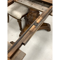 Mid to late 20th century American walnut dining table, the cross banded and quarter sawn veneered top with leaf carved frieze raised on two baluster turned and leaf carved pedestals with trefoil platform bases and reeded and scrolled feet, (200cm/290cm x 118cm, H77cm) together with a set of six (4+2) matching walnut dining chairs, with shield backs, damask covered seat pads and turned and reeded front support (W65cm)