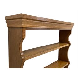 'Beaverman' oak wall hanging plate rack, moulded cornice over three shelves, shaped end supports, by Colin Almack of Sutton-under-Whitestonecliffe