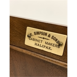 Edwardian walnut bedside cupboard, raised back over carved frieze and panelled door enclosing one shelf, raised on shaped plinth base, bearing ivorine plaque reading 'T. Simpson and Sons, Cabinet makers, Halifax'