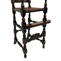 Victorian style stained beech child's high chair, scroll carved and pierced cresting rail over cane work back and seat, turned upright supports and moulded sweeping arms, on turned supports with scroll carved lower stretcher