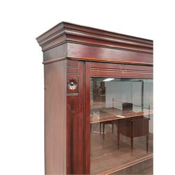 Late 19th century walnut bookcase on cupboard, the projecting cornice over two glazed doors, enclosing three adjustable shelves over two drawers and two cupboard doors, raised on a plinth base 