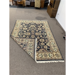 Persian design blue carpet, interlaced trailing foliate of blues, greens, oranges ivory and reds on a navy field, encased by guarded border, 390cm x 275cm