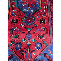 Persian Hamadan red ground rug, the field decorated with stylised flowerhead and bird motifs, the guarded border decorated with repeating geometric design