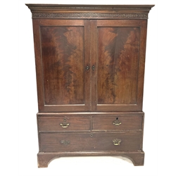 Georgian mahogany linen press with dentil cornice over blind fret work frieze, two panelled doors enclosing oak slides, two short and one long drawer to base, raised on bracket supports, W127cm, H180cm, D62cm