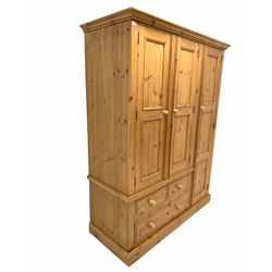 Waxed pine triple wardrobe, cornice over full length cupboard and two others with interior fitted for hanging, three drawers under, raised on plinth base W153cm, H193cm, D62cm