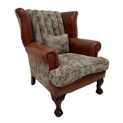 Traditionally shaped wingback club armchair, upholstered in part paisley patterned fabric part tan leather with leather piping, hardwood framed, on ball and claw carved feet, together with complementary scatter cushion 