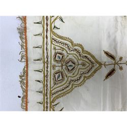 19th century silk embroidered panel or table runner, embroidered in silvered metal thread with scrolling foliage and fringed border, 112cm x 54cm, together with a bright embroidered panel, possibly Turkish and another (3)