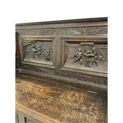 Late 19th century carved oak monks bench, the back panel with carved figures over hinged seat and base with carved masks 