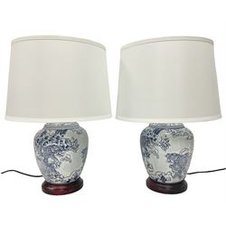 Pair of lamps of baluster form, decorated with fish in foaming waves, raised upon a circular base, including shades H53cm
