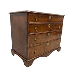 George I walnut chest, rectangular quarter veneered top with moulded edge, decorated with ebony and fruitwood stringing, fitted with four graduating drawers, the crossbanded facias with fruitwood stringing in interlocking demi-lune form, lower moulded edge over later bracket feet
Provenance: From the Estate of the late Dowager Lady St Oswald