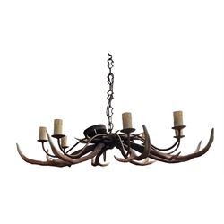 David Hunt faux stag antler chandelier, comprising eight metal branches with candle sconces, above a series of rustic painted faux antlers, W115cm approx