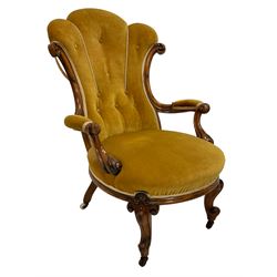 19th century walnut framed open armchair, scallop shaped  back with c-scroll uprights, upholstered in yellow buttoned velvet fabric with sprung seat, arm terminals carved with acanthus leaves, raised on scrolling cabriole supports with castors