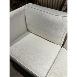 Large two seat sofa, upholstered in cream cotton fabric, raised on turned bun feet