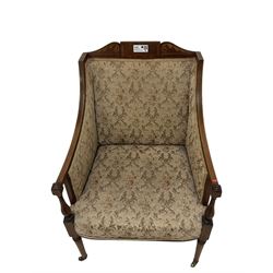 Edwardian inlaid mahogany upholstered armchair, cresting rail with scrolling foliate satinwood inlays and ebony stringing, upholstering in floral patterned fabric with sprung seat, on tapering supports and castors