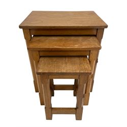 'Mouseman' oak nest of three tables, rectangular adzed tops on octagonal supports joined by pegged stretchers, each table carved with mouse signature, by Robert Thompson of Kilburn 