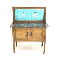 Arts & Crafts period oak washstand with grey and white marble top and light blue tiled back with two tube lined contrasting tiles, panelled double cupboard below, on square supports with castors, W91cm, H118cm, D45cm