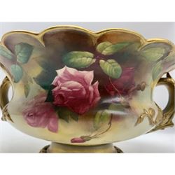 Early 20th century Royal Worcester twin handled footed bowl of squat baluster form with scalloped rim, hand painted with roses, unsigned, upon pedestal base,  with puce printed marks beneath including shape number 2344, and date code for 1910, L29cm x H13cm