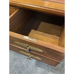 French Empire walnut writing desk, the rectangular and leather inlayed top, with two leather inset slides, over four drawers, mirrored by three faux drawers, raised on turned supports with gilt metal mounts, united by an X stretcher 