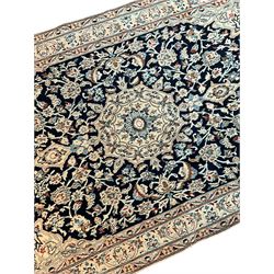 Fine Persian Nain ivory ground rug, wool with silk inlay, central pole medallion within an indigo field decorated with scrolling palmettes, the contrasting spandrels with floral patterns, the guarded border with repeating plant motifs
